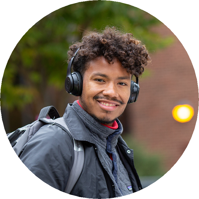 image of Smiling Student. man with beard in a library
